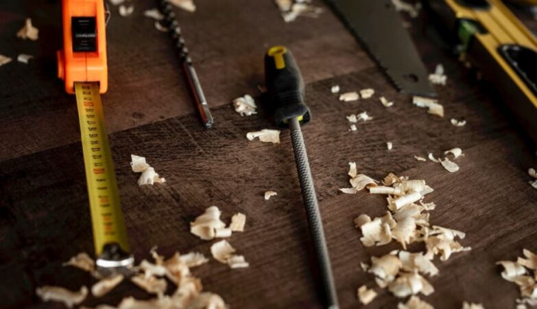Messwerkzeuge und Hobelspäne auf dunklem Holz