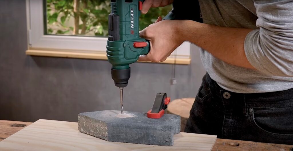 Ein Mann benutzt eine Parkside Akku-Bohrhammer-Bohrmaschine