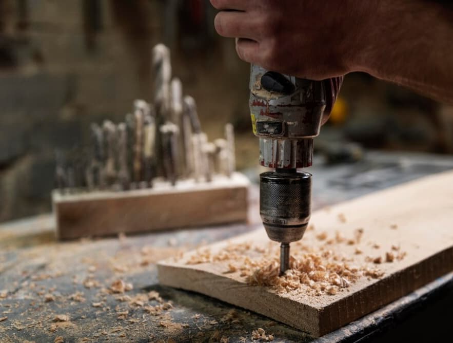 Nahaufnahme von Bohrarbeiten in Holz mit Holzspänen