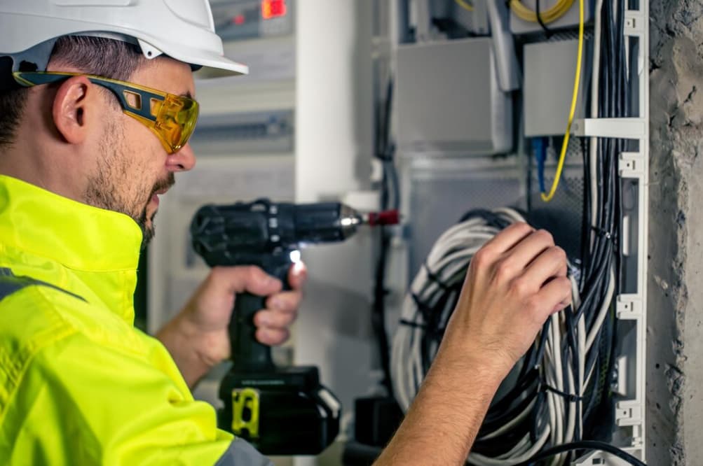 Ein Elektriker arbeitet an einem Schaltkasten