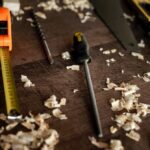 Messwerkzeuge und Hobelspäne auf dunklem Holz